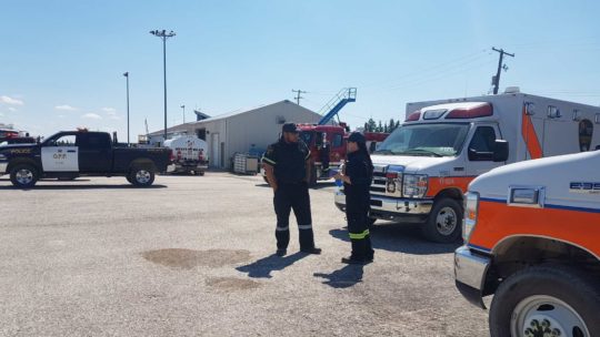 WAHA paramedics stand in front of two ambulance trucks talking