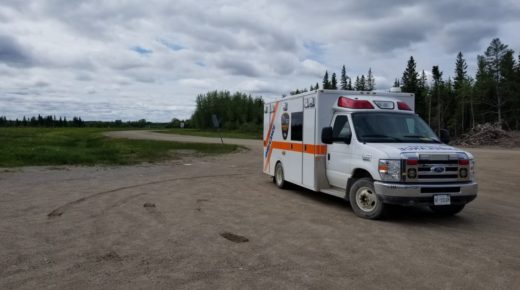 Ambulance in the rural area among fields and forest