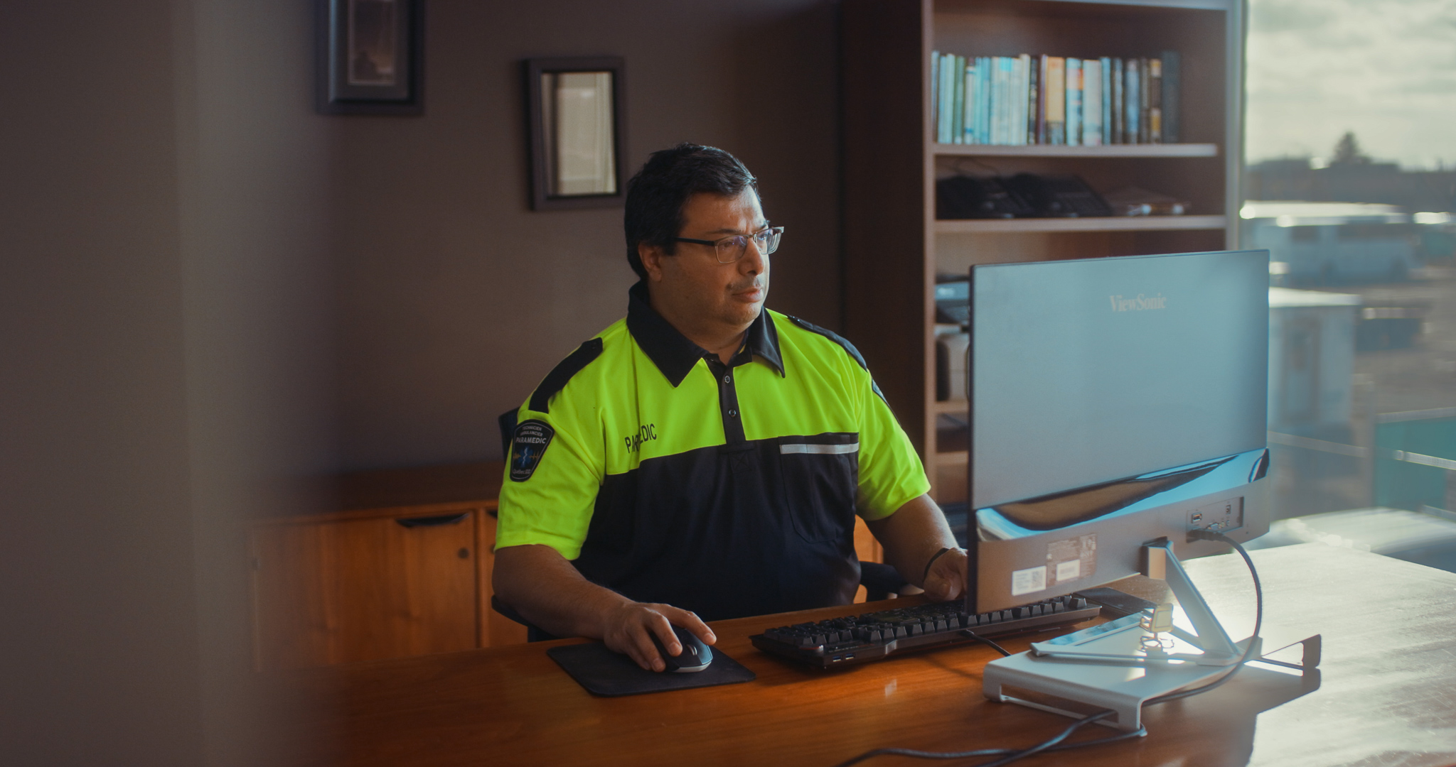 Deputy Chief of Paramedic Services sits at his desk looking at the computer screen